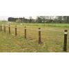 Potelets anti-stationnement en bois sur un terrain en terre