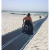 Fauteuil roulant sur tapis d'accès plage bleu en polyester