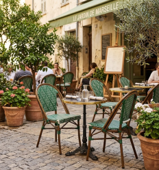 Chaise bistrot aluminium et rotin naturel sur terrasse de restaurant